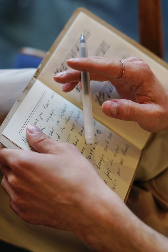contact-img Close-up image of a woman writing with a pen in a notebook. Ideal for themes of creativity and songwriting.